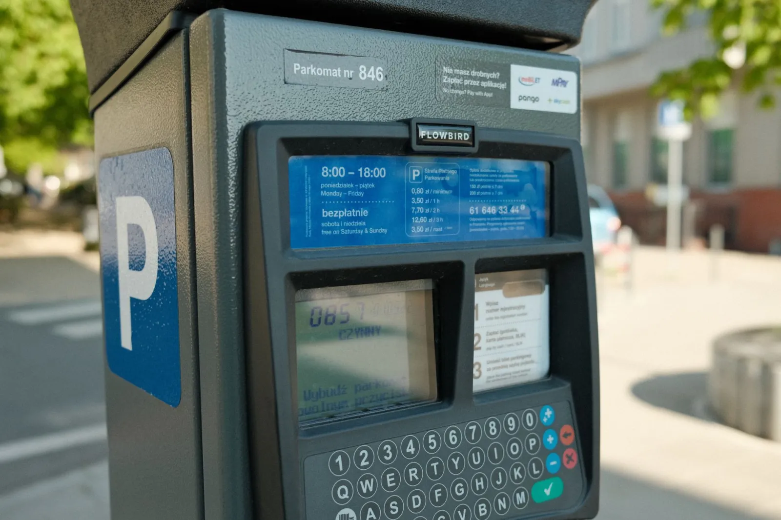 Close-up of a parking meter with digital interface in a city street.